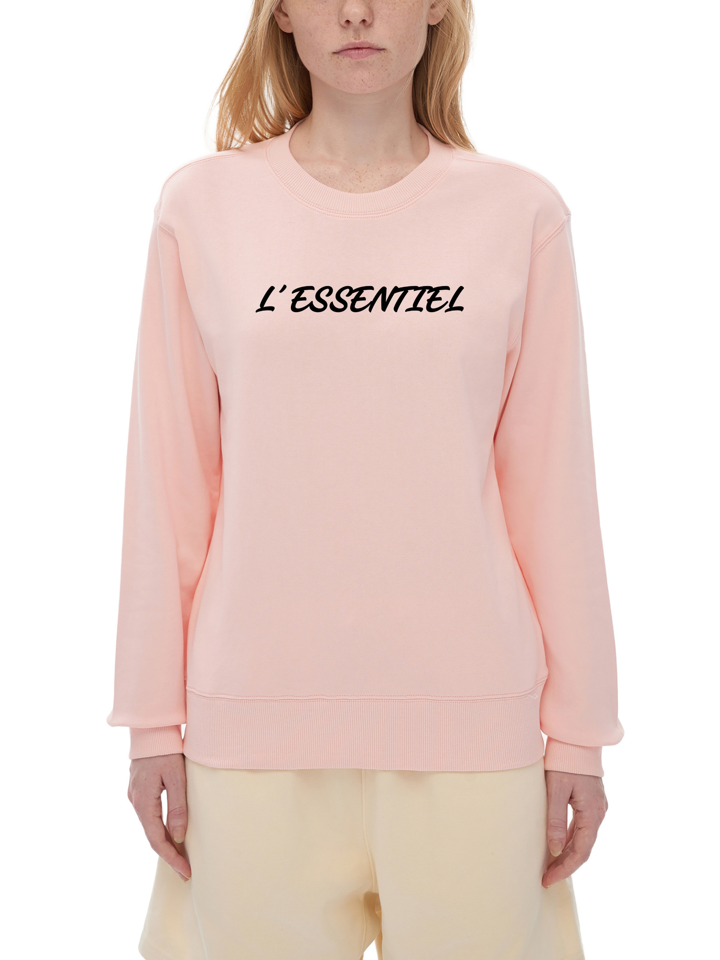 Person wearing a pink sweatshirt with 'L'ESSENTIEL' text on a white background