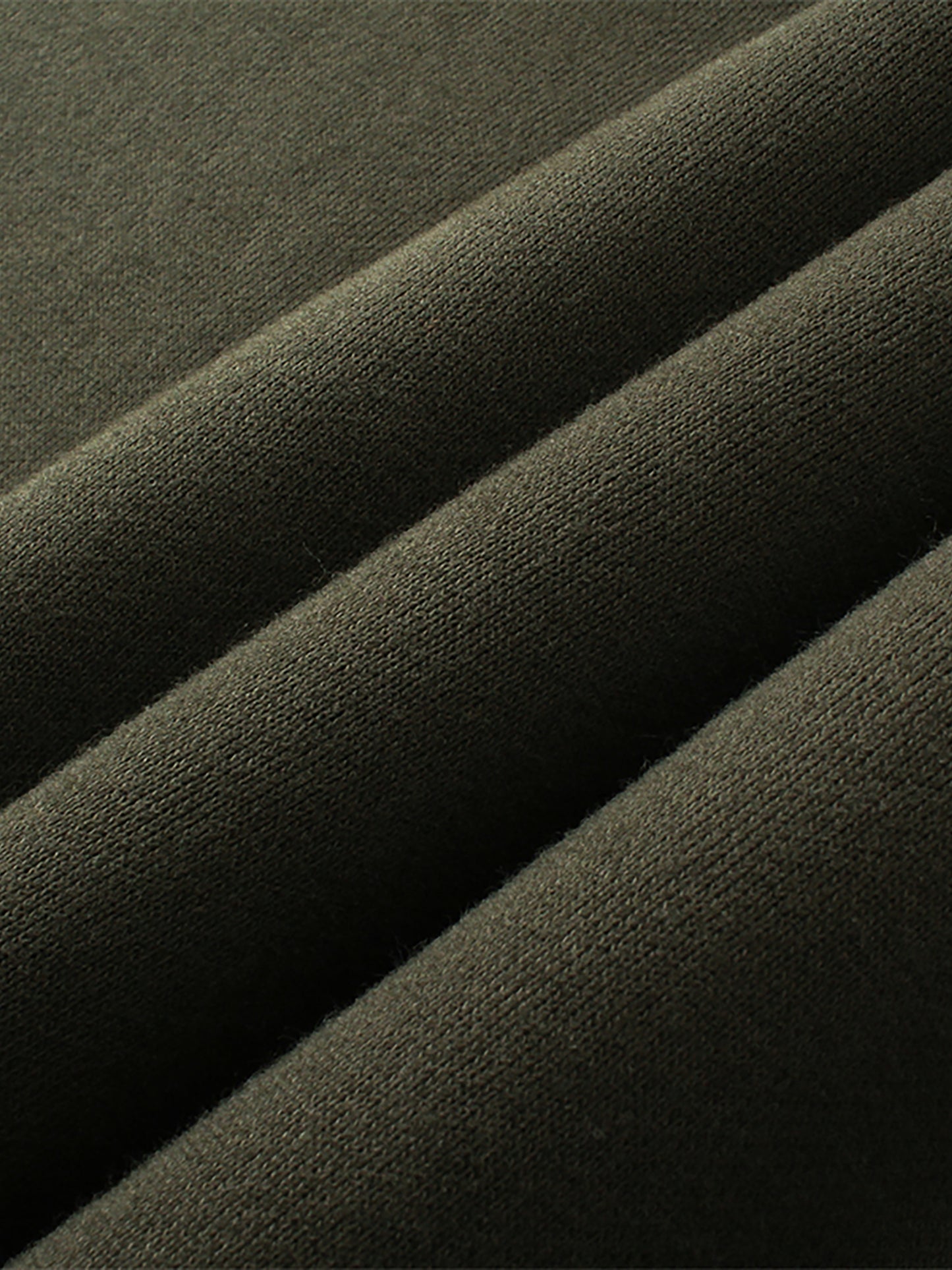 Close-up of dark green fabric with folds
