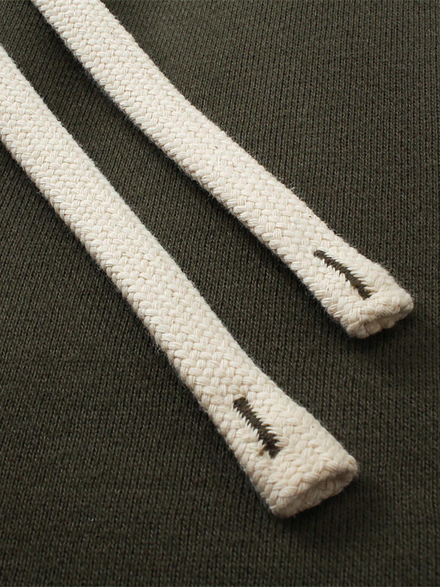 Close-up of white shoelaces with a brand logo on a dark background