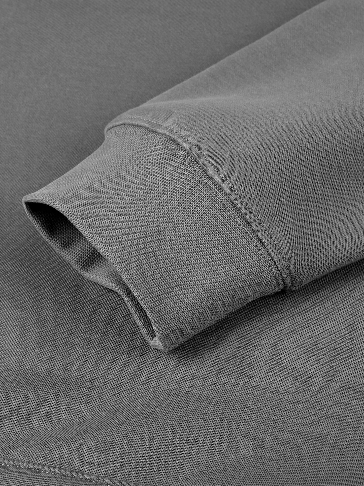 Close-up of a gray fabric with a rolled-up sleeve on a matching gray background