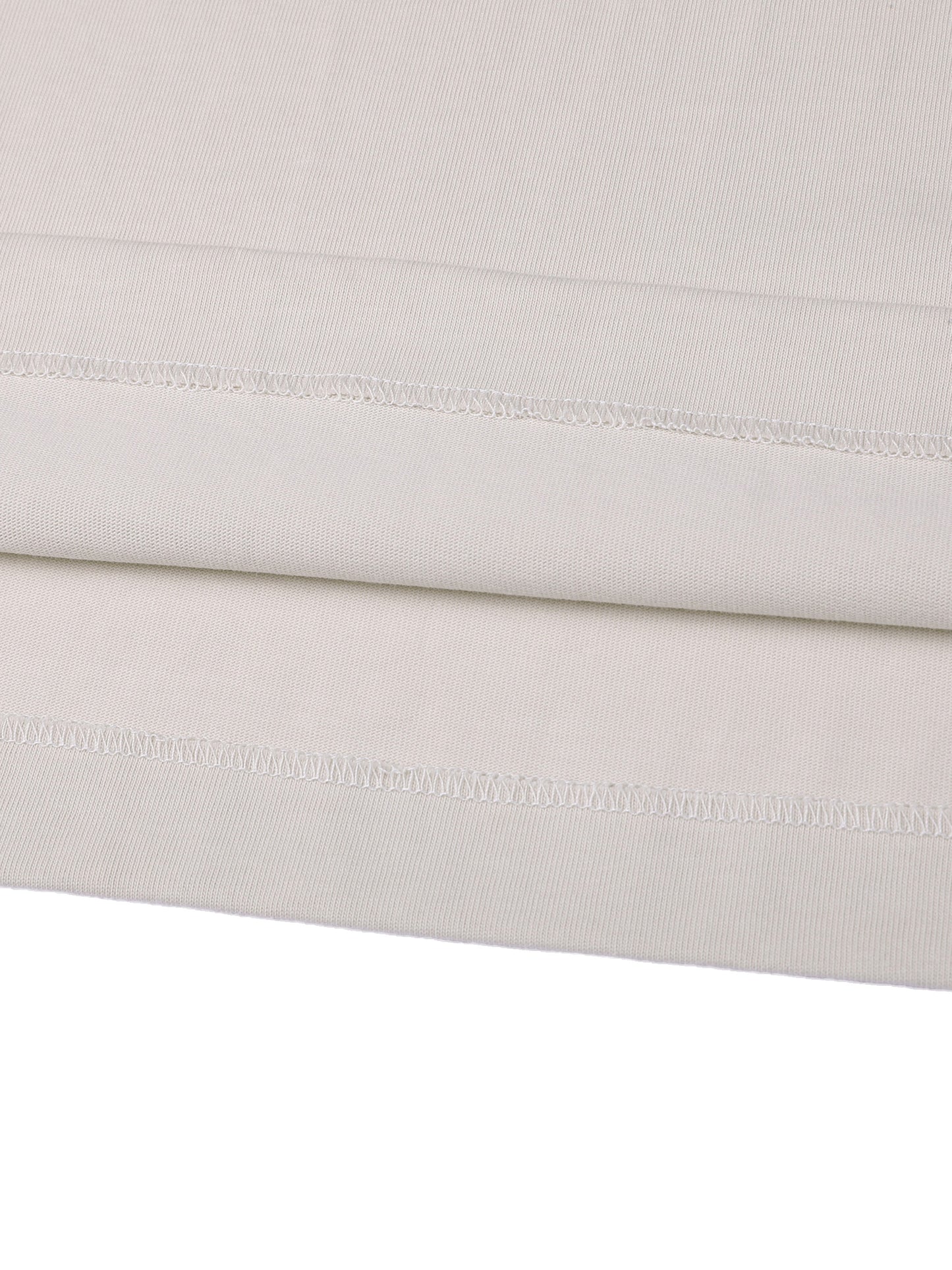 Close-up of a folded light gray fabric with visible stitching on a white background