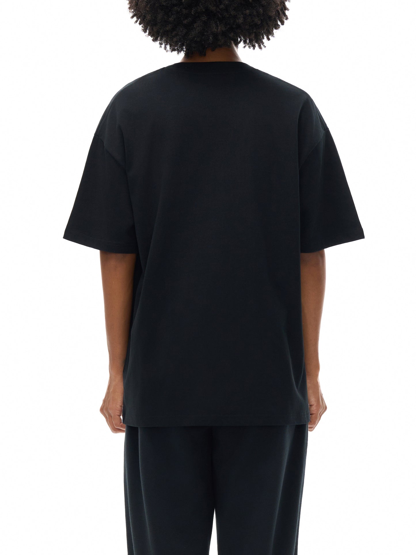 Person wearing a black t-shirt and pants on a white background