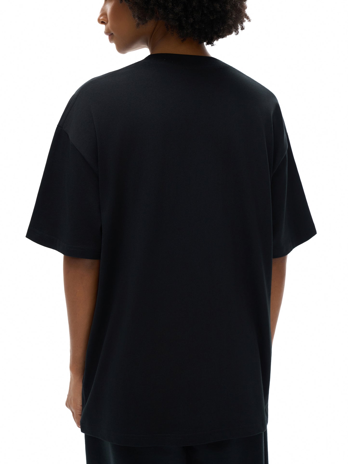 Person wearing a black t-shirt on a white background
