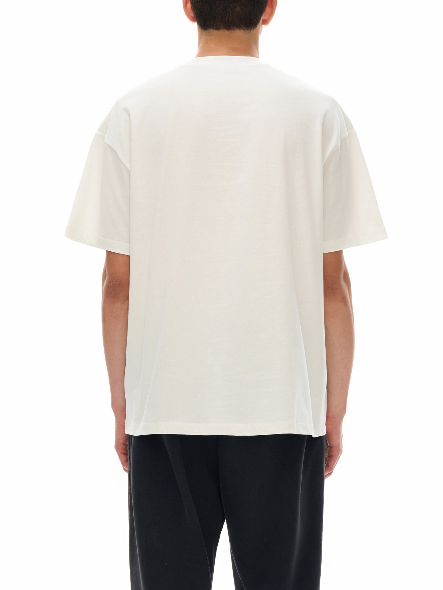 Person wearing a plain white t-shirt on a white background