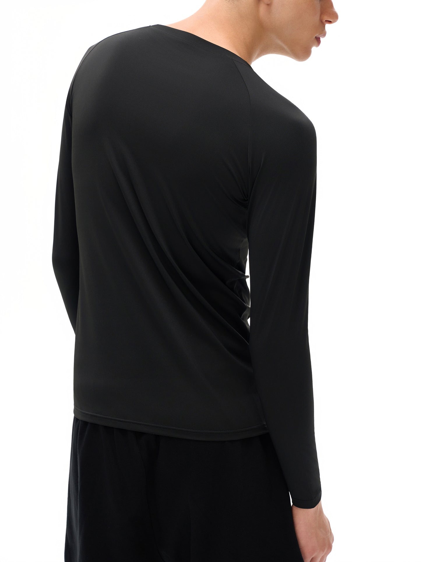 Person wearing a black long-sleeve shirt on a white background