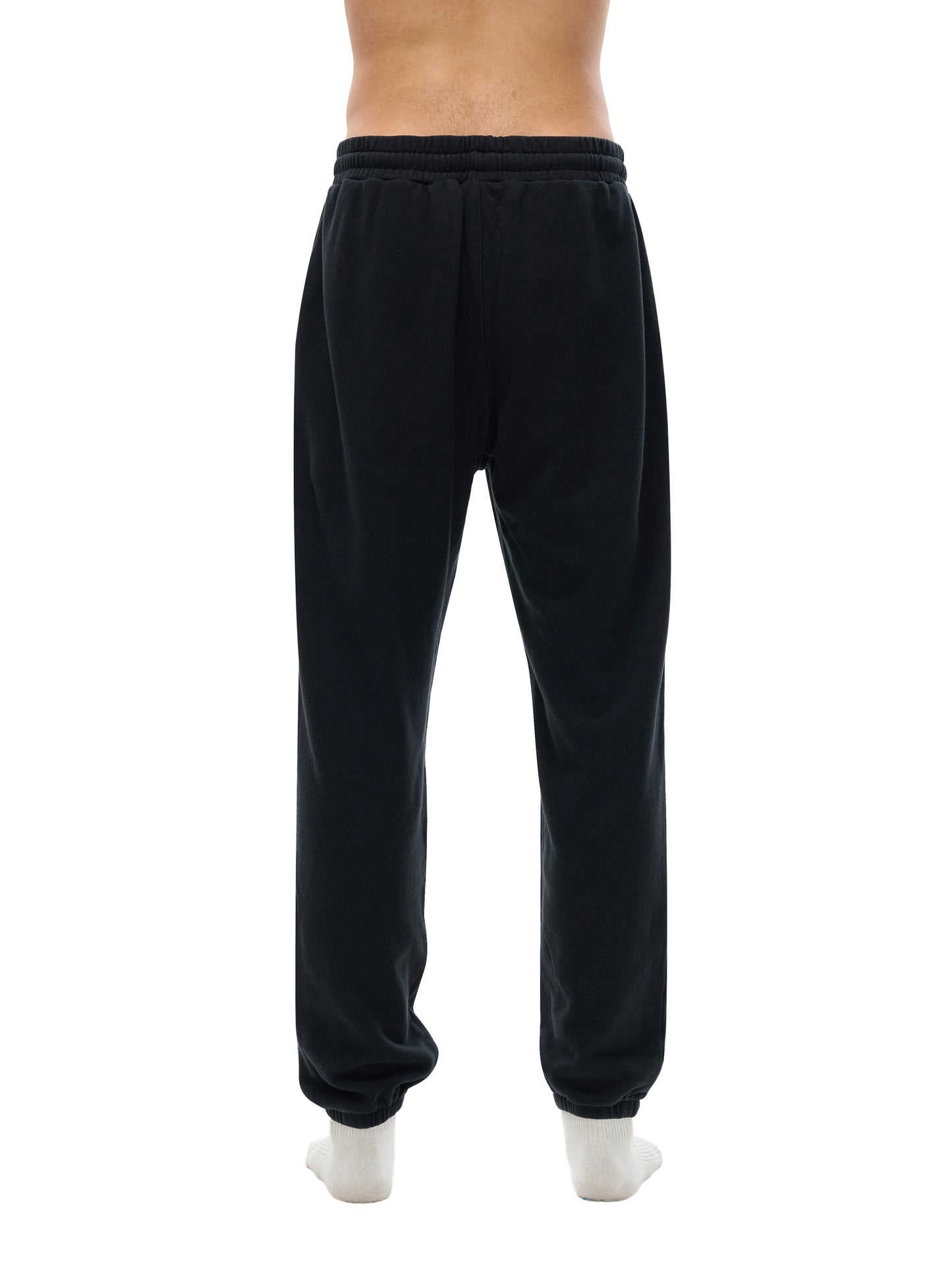 Black sweatpants worn by a person on a white background