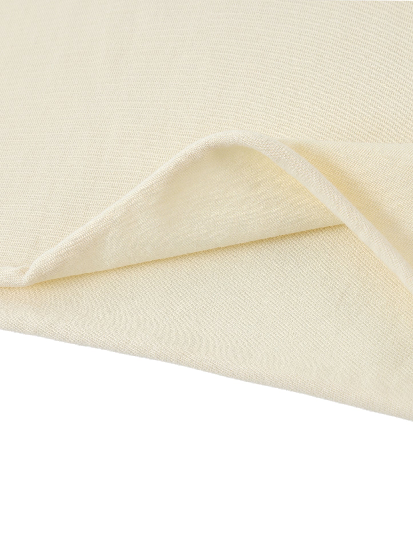 Close-up of a folded cream-colored fabric on a white background