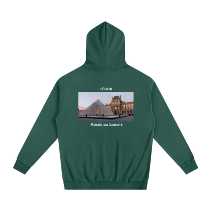 Green hoodie with a printed design on the back featuring the Louvre Museum.