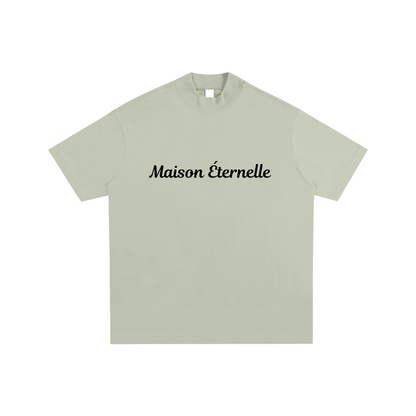 Light green t-shirt with 'Maison éternelle' text on a white background