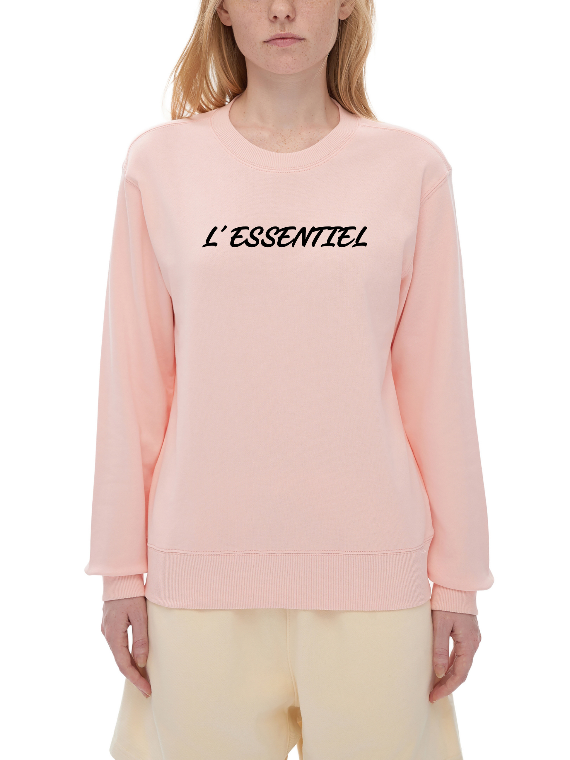 Person wearing a pink sweatshirt with 'L'ESSENTIEL' text on a white background