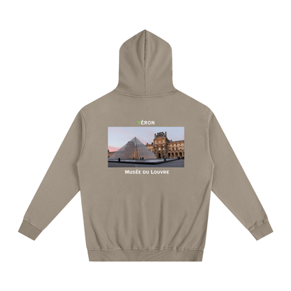 Beige hoodie with a graphic of the Louvre Museum on the back