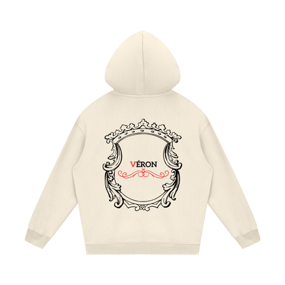 Beige hoodie with decorative emblem and 'Véron' text on a white background