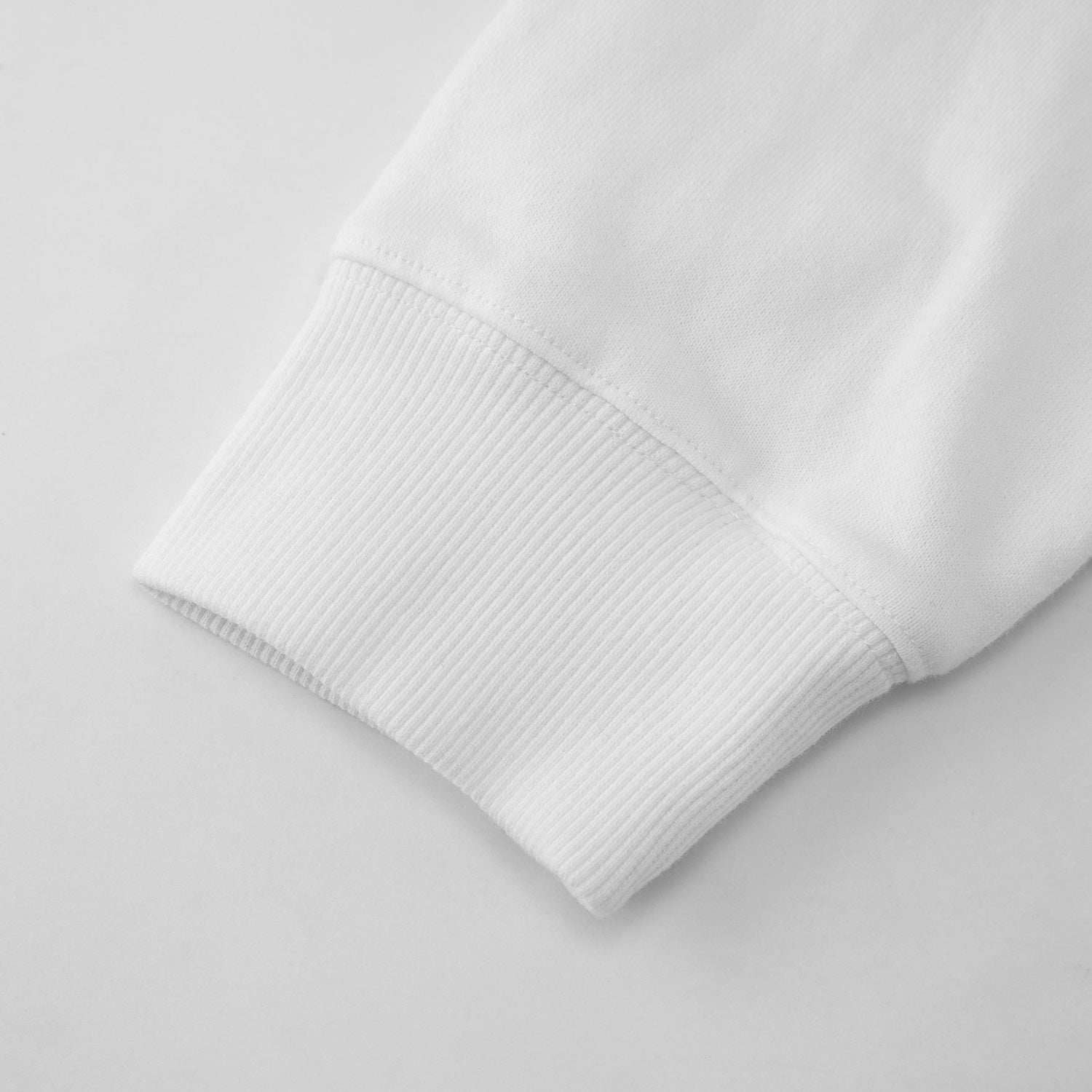 Close-up of a white sweater sleeve on a light gray background