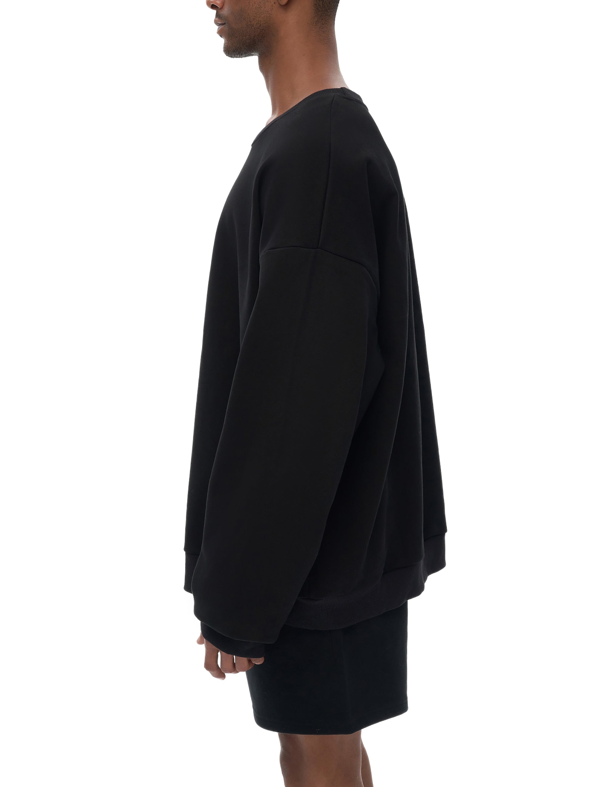 Model wearing VÉRON oversized streetwear sweater in urban setting 4