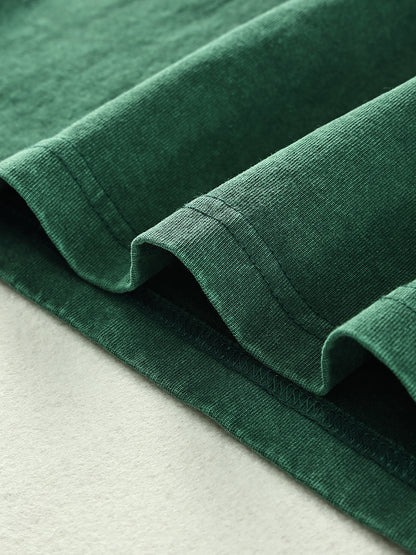 Close-up of green fabric with a textured surface on a light gray background