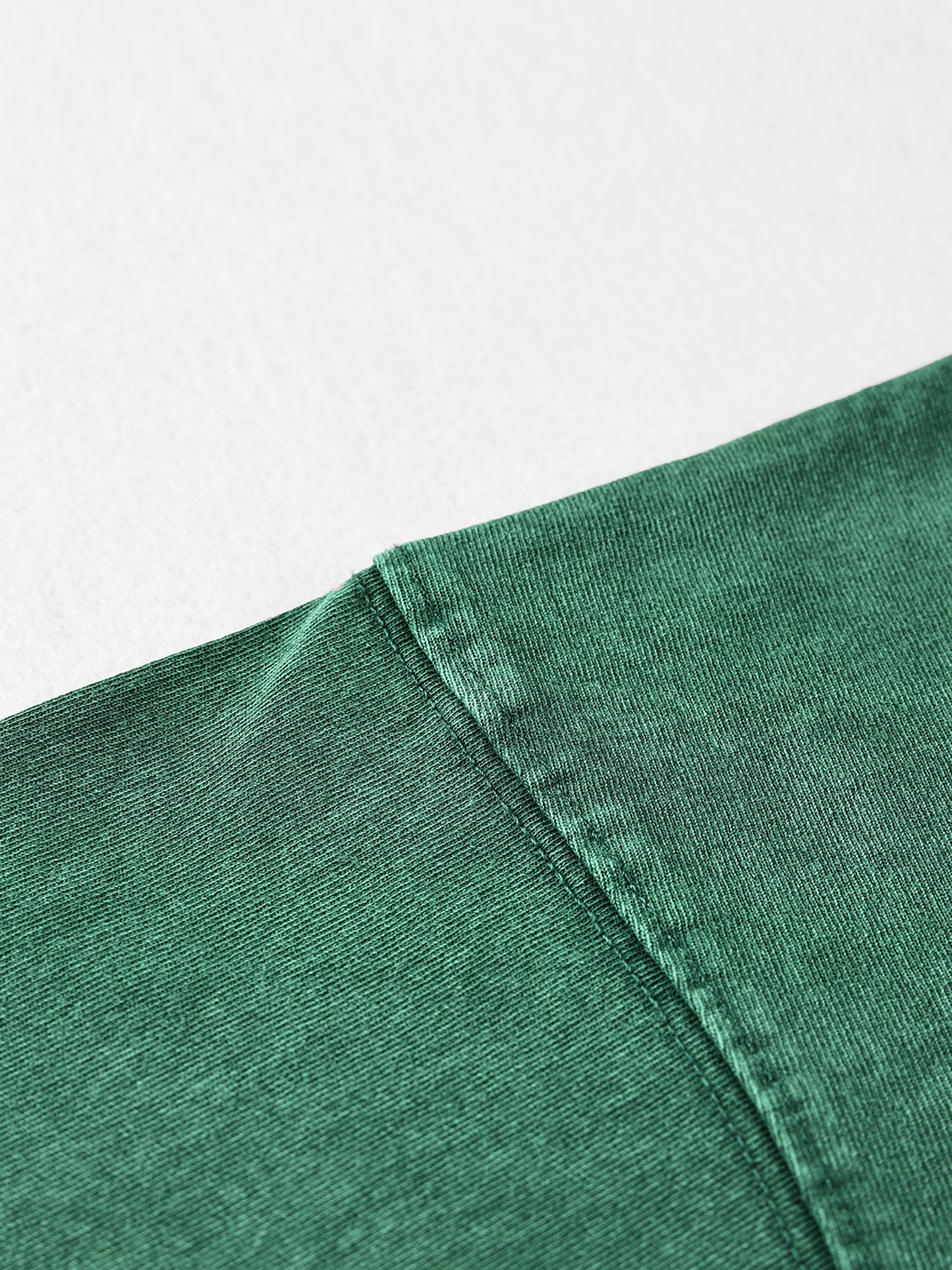 Close-up of a green fabric edge on a light gray background