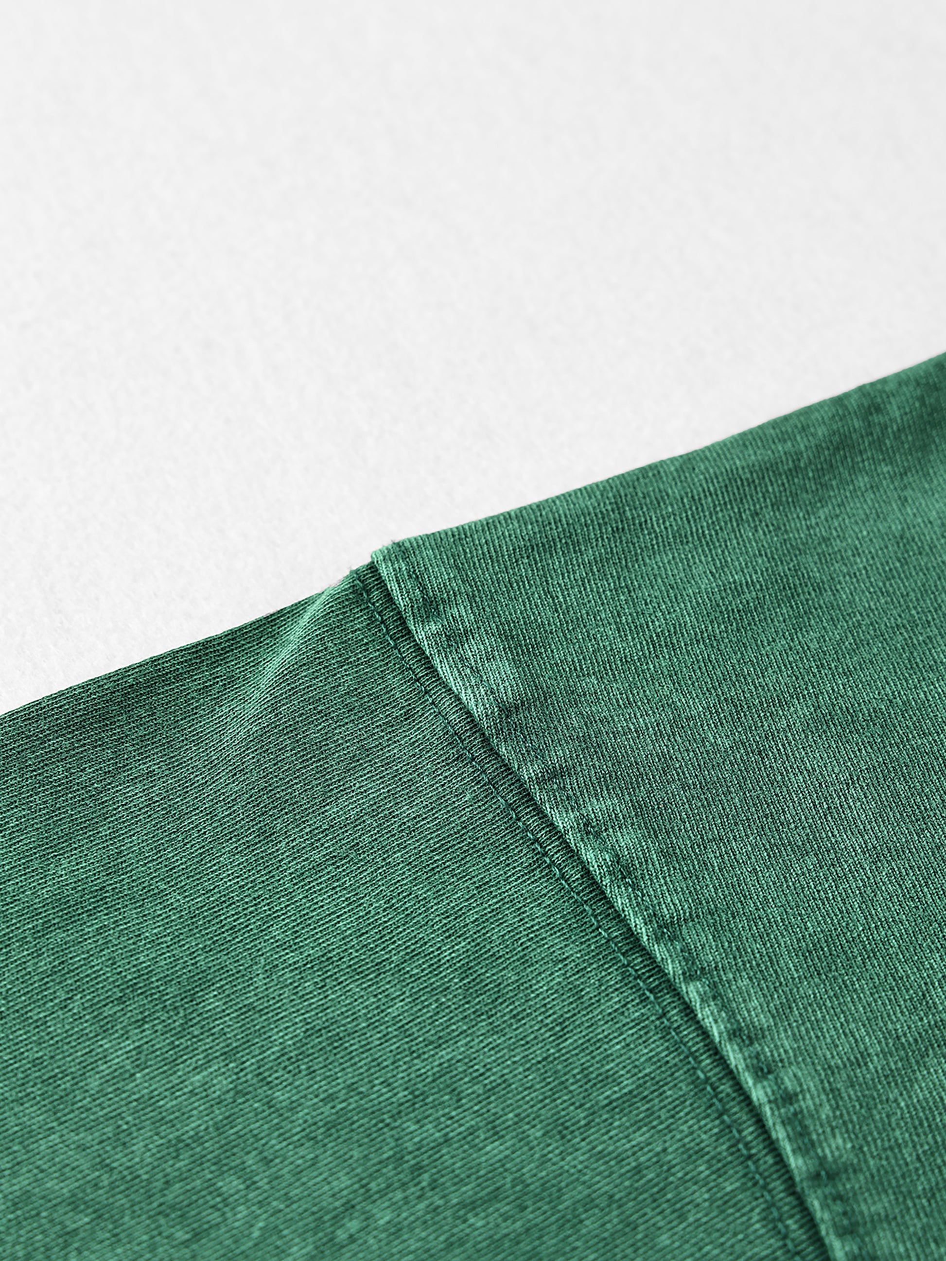 Close-up of a green fabric edge on a light gray background
