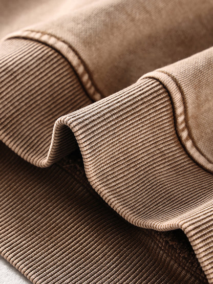 Close-up of brown corduroy fabric with a focus on texture and stitching.