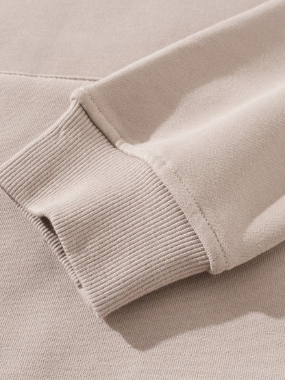 Close-up of a beige sweater sleeve with ribbed texture.