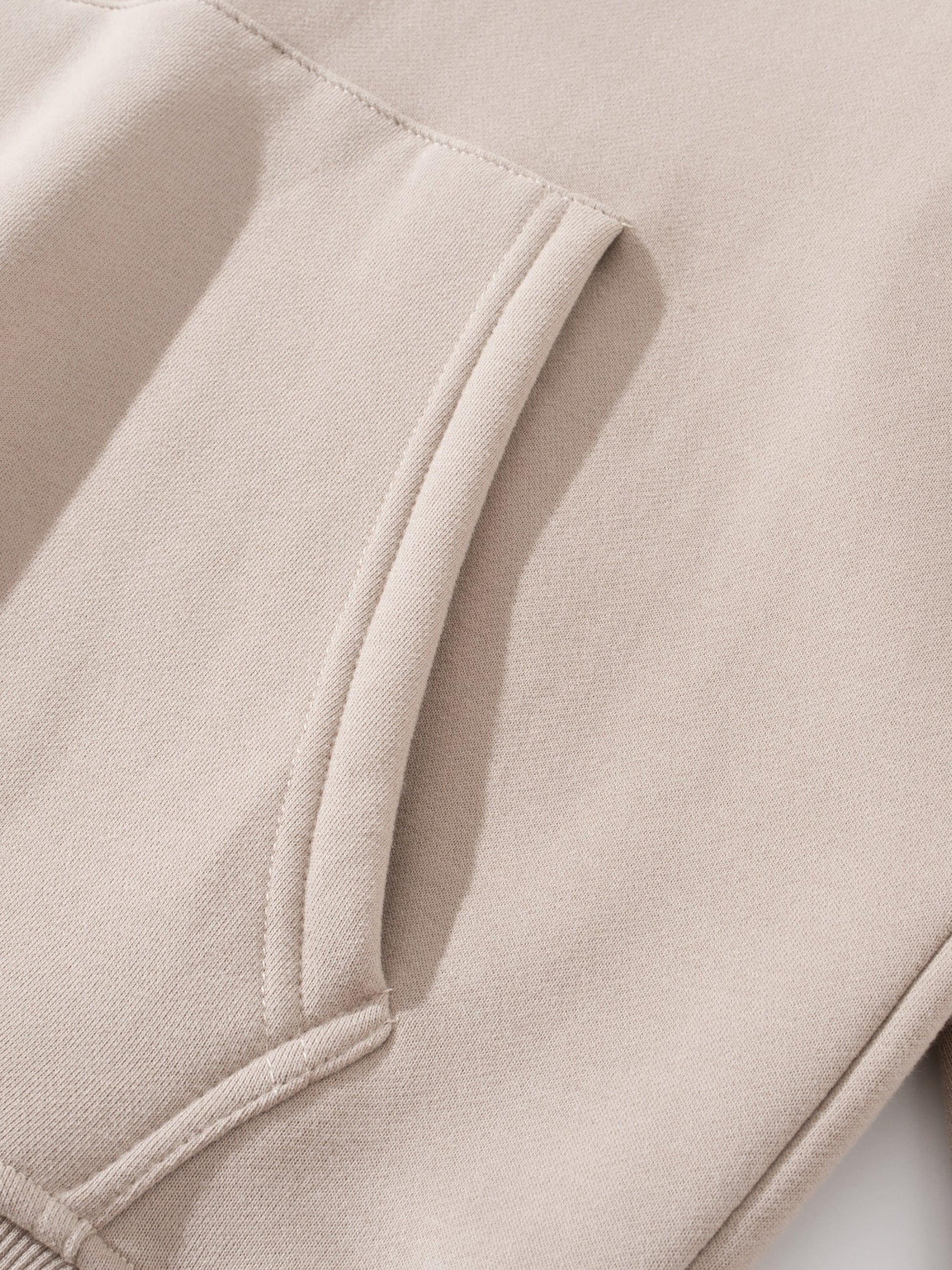 Close-up of beige fabric with a pocket detail