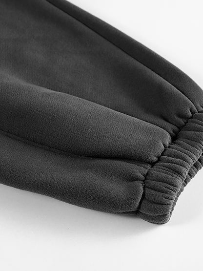 Close-up of dark gray fleece pants on a white background