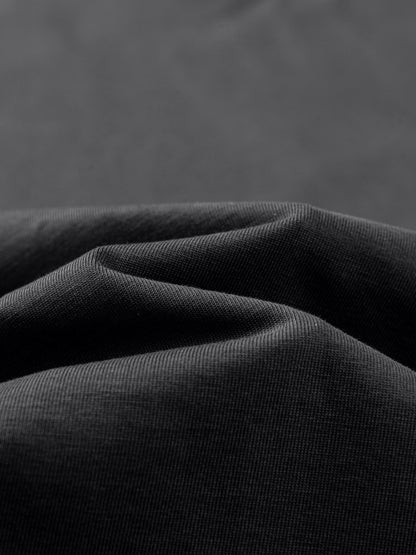 Close-up of dark gray fabric with folds on a matching background