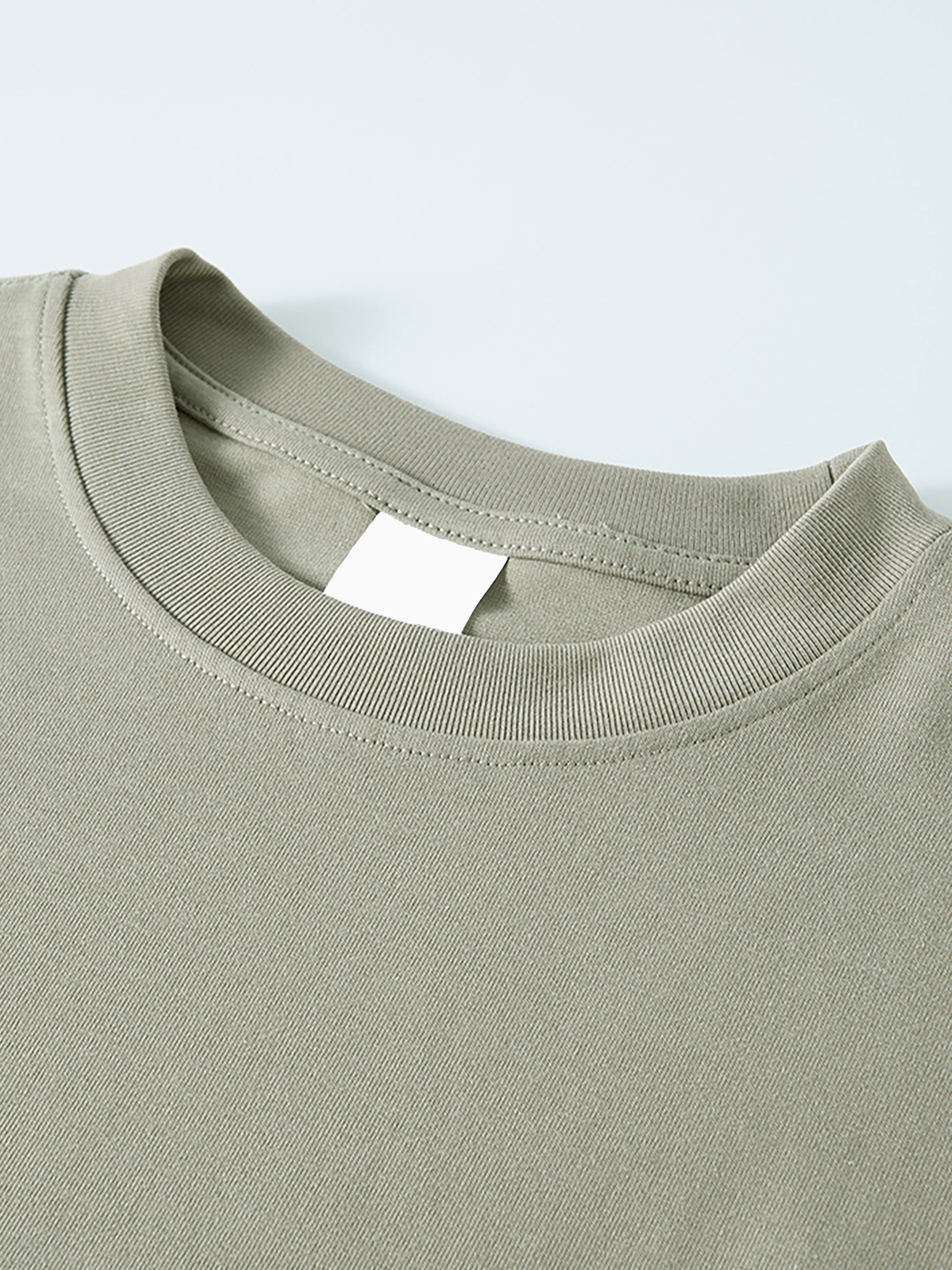 Close-up of a green t-shirt with a label on a light gray background