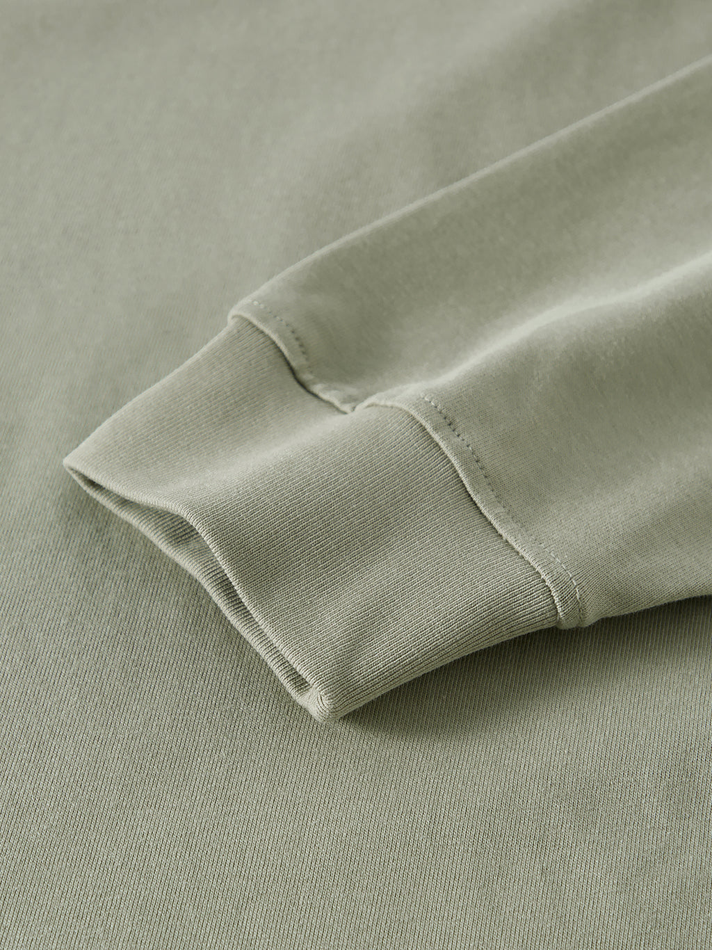 Close-up of a folded green fabric edge on a matching background