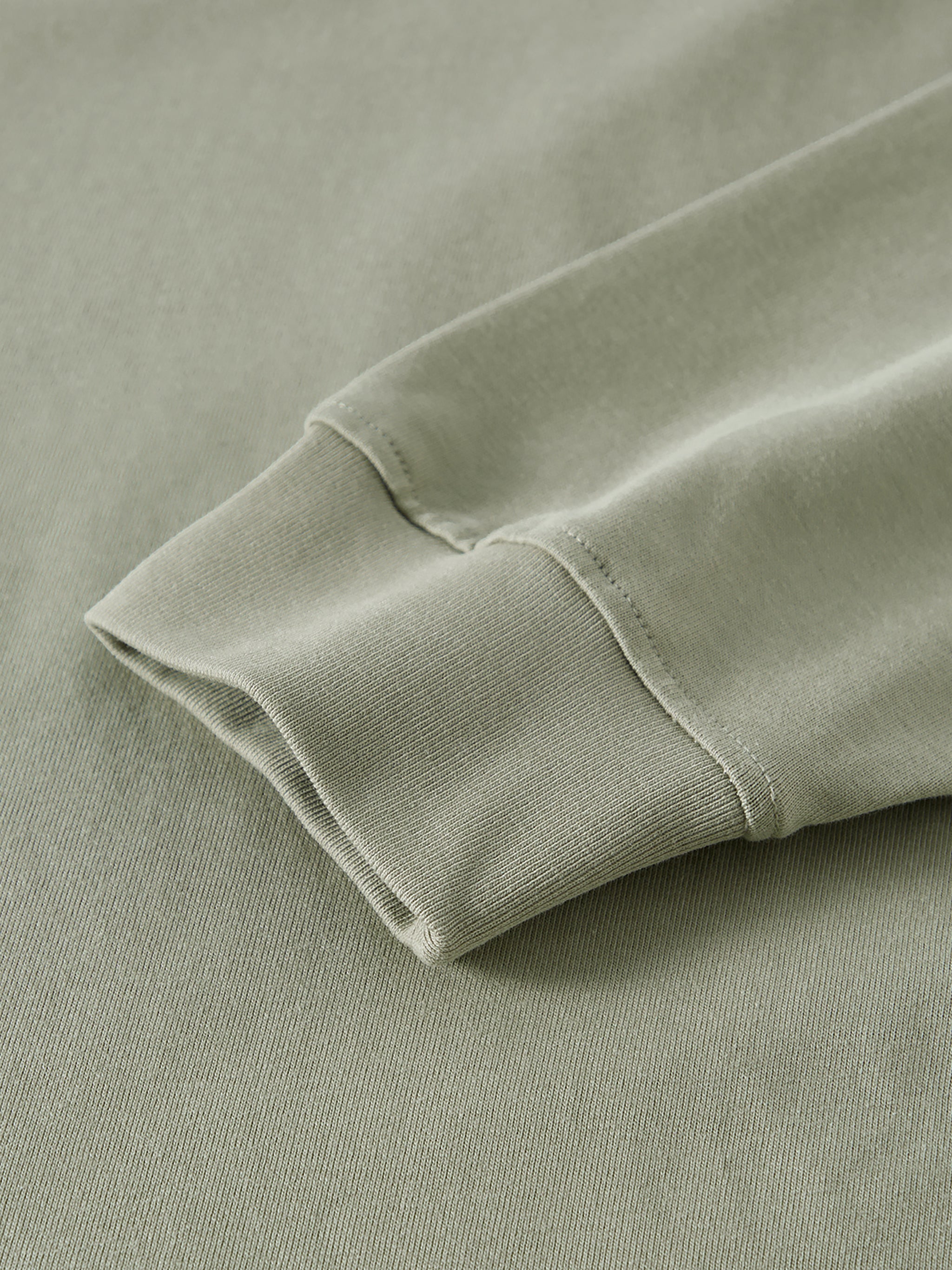 Close-up of a folded green fabric edge on a matching background