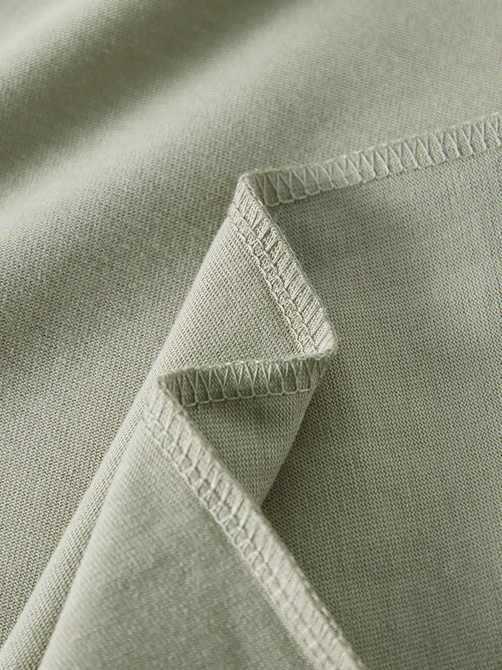 Close-up of a green fabric with stitching detail