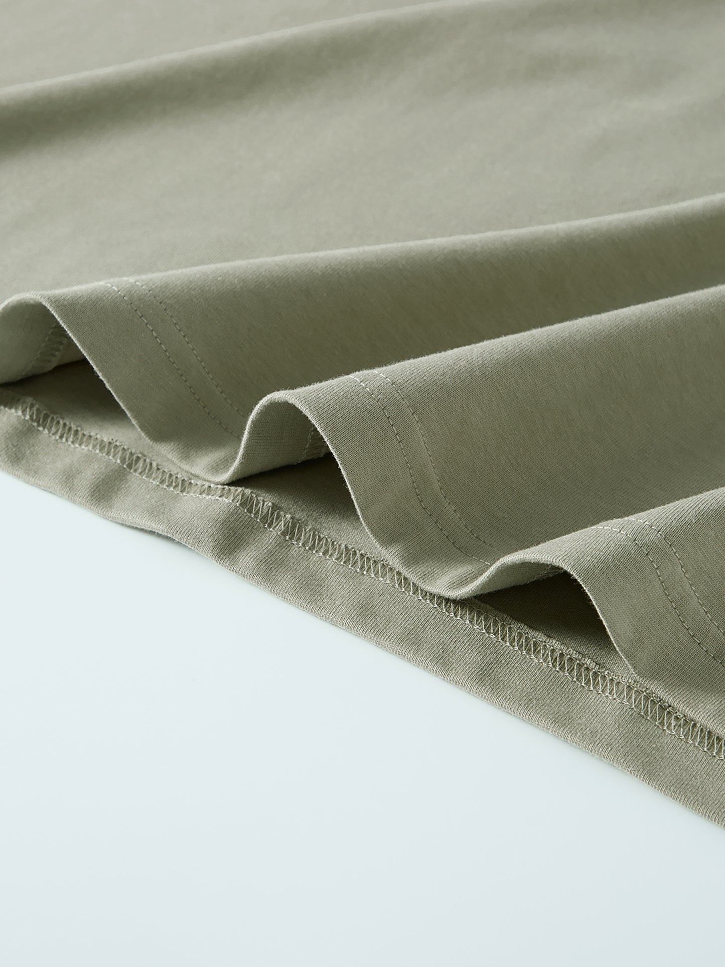 Close-up of a folded green fabric on a light gray background