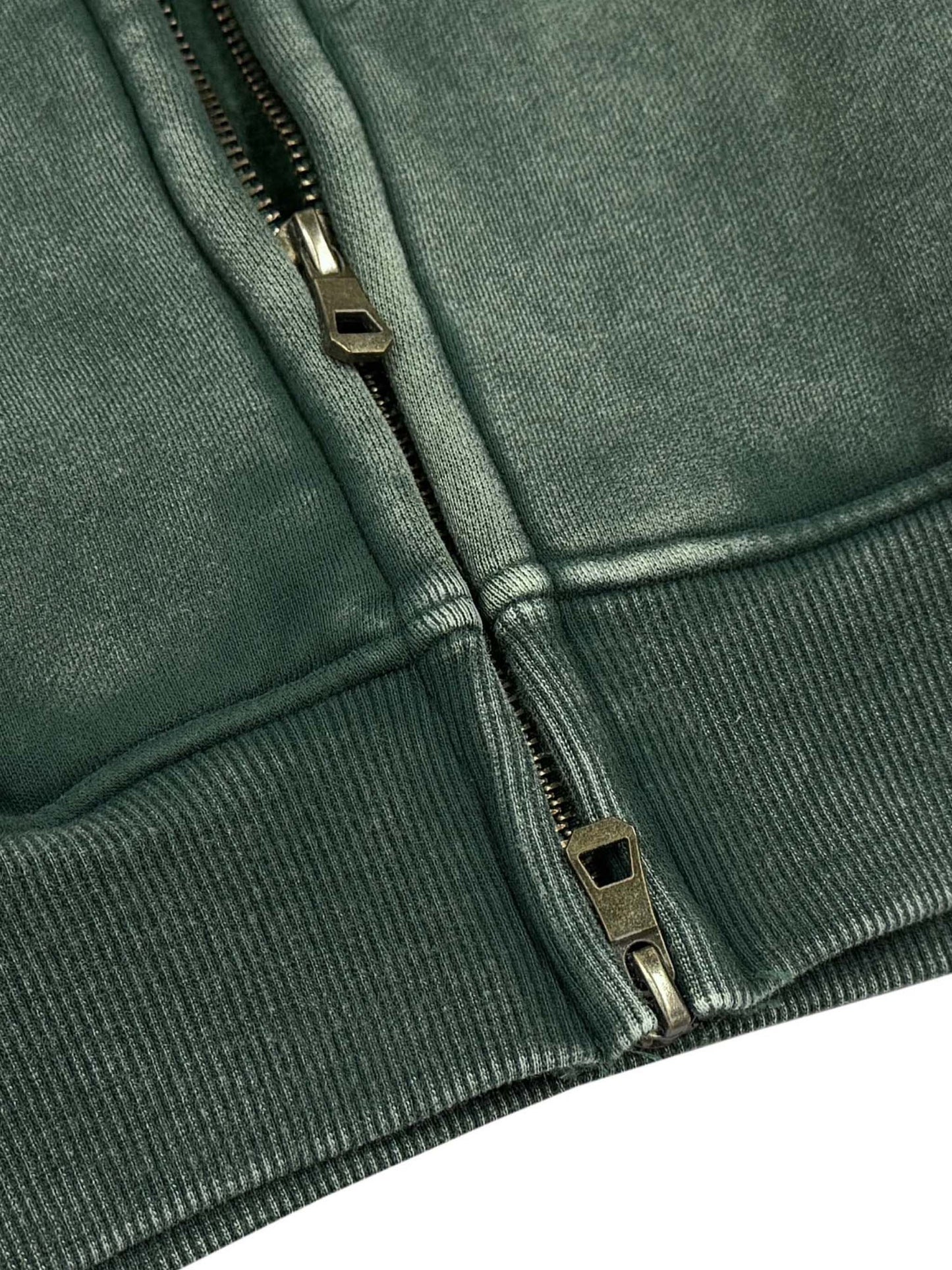 Close-up of a green jacket zipper on a white background