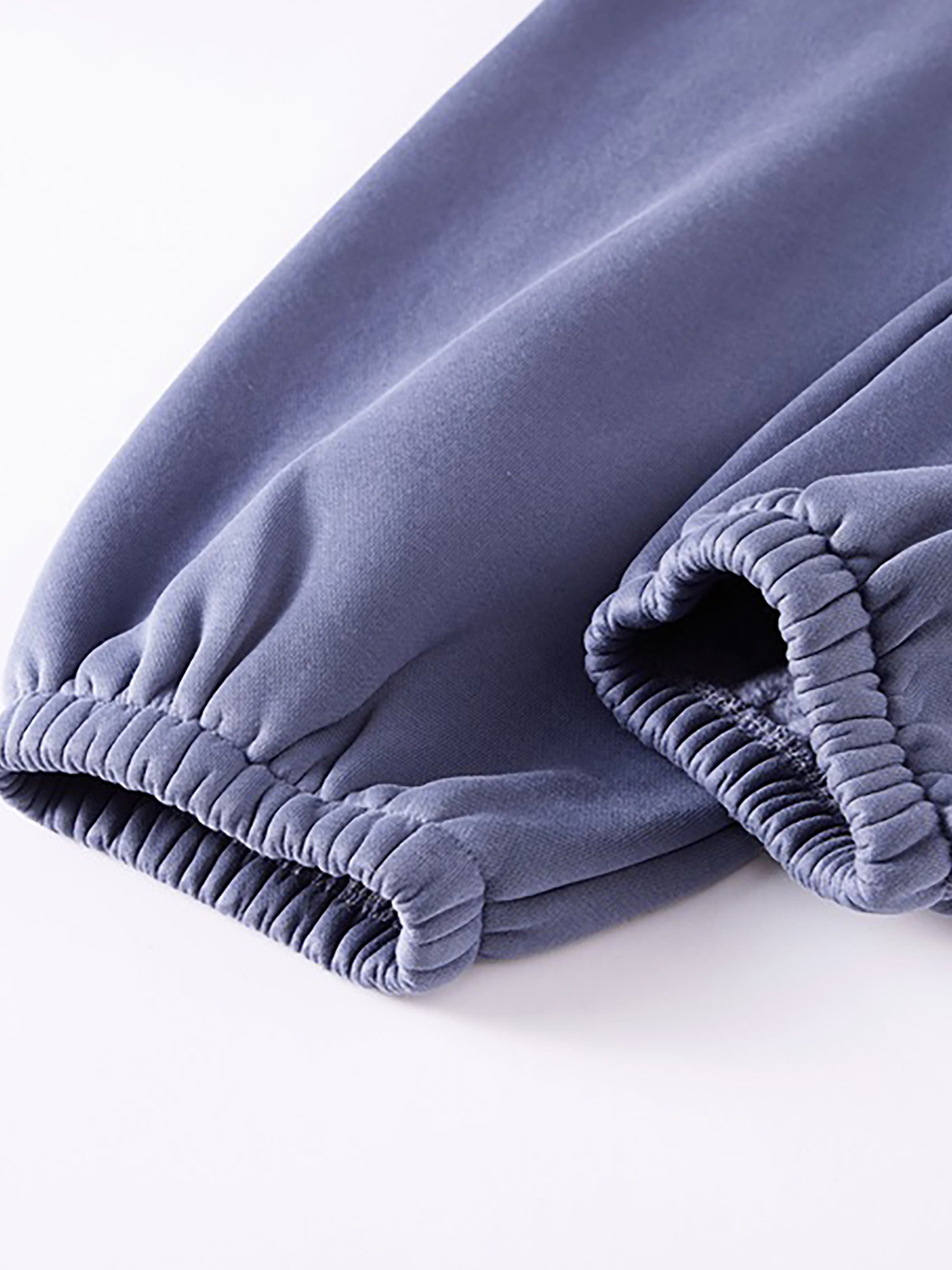 Folded purple pants on a white background