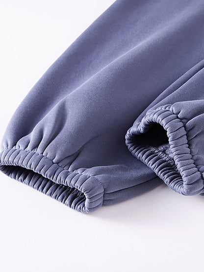 Folded purple pants on a white background