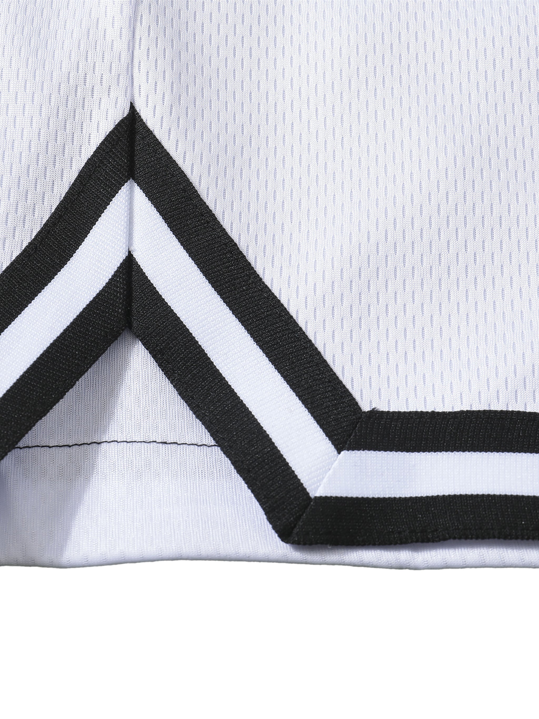 Close-up of a white short with black and white striped trim on a white background