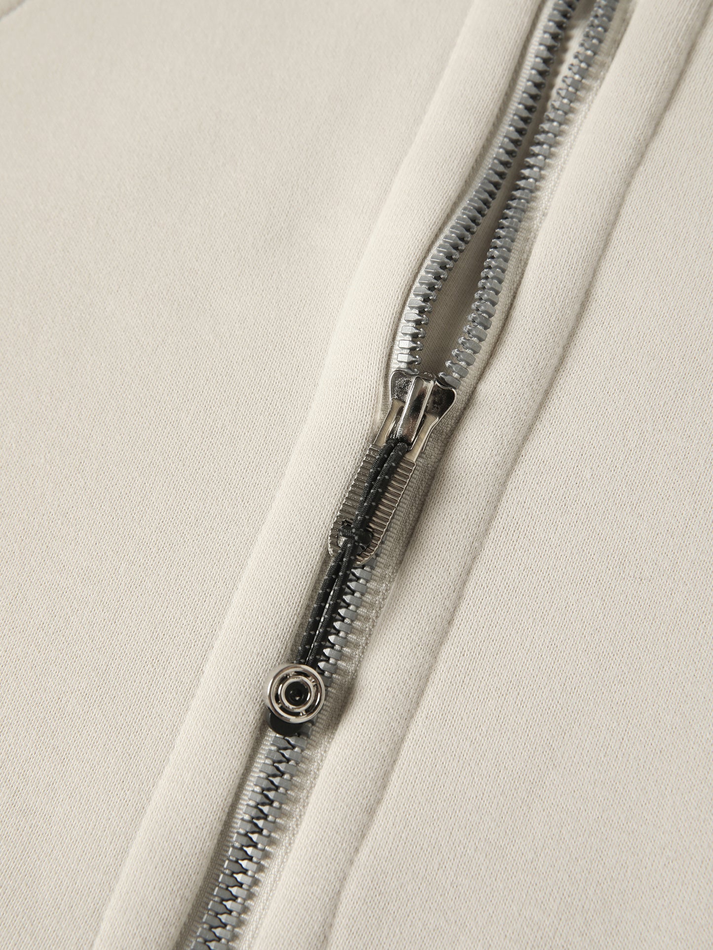 Close-up of a zipper on a beige fabric background