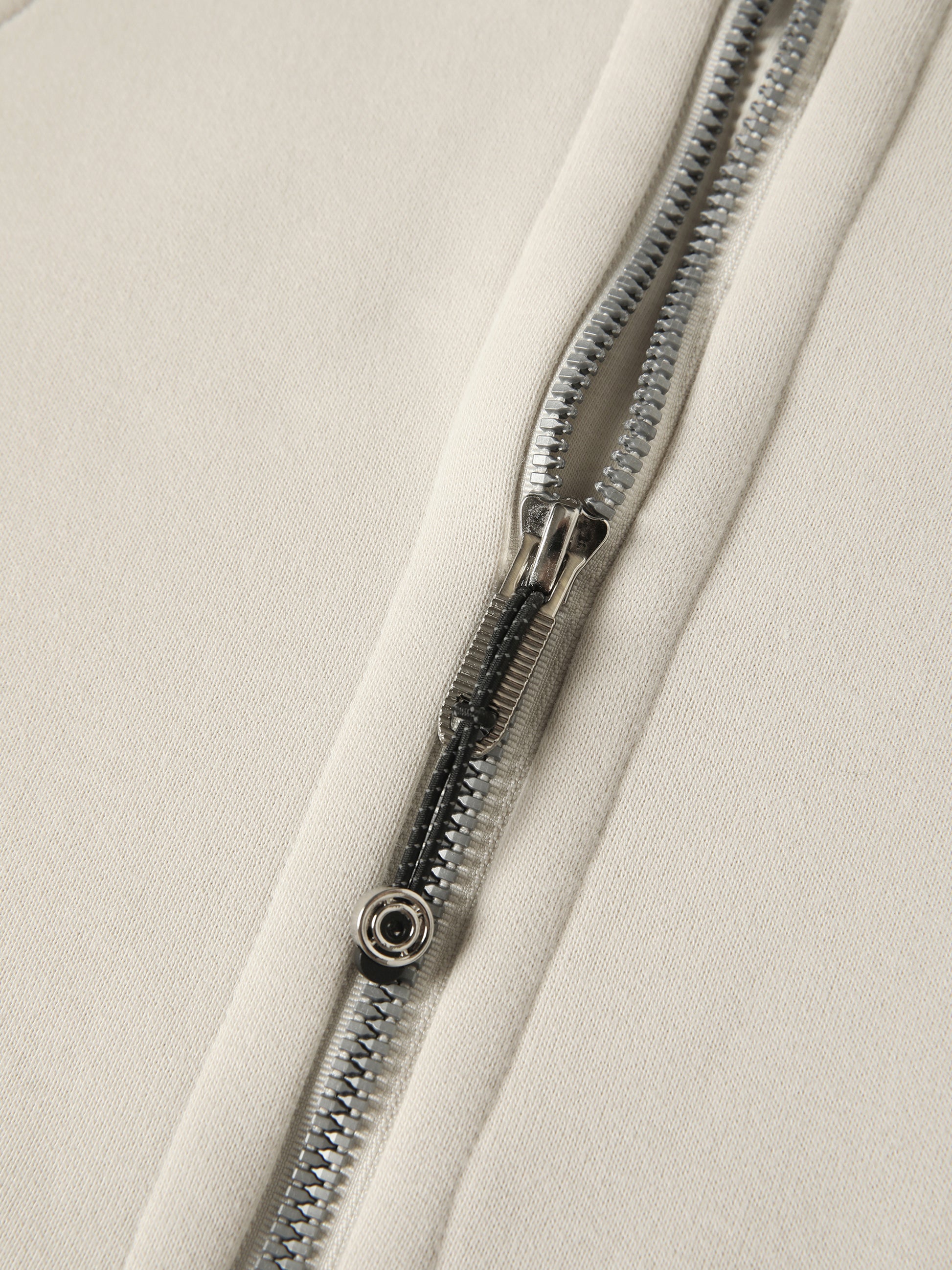 Close-up of a zipper on a beige fabric background