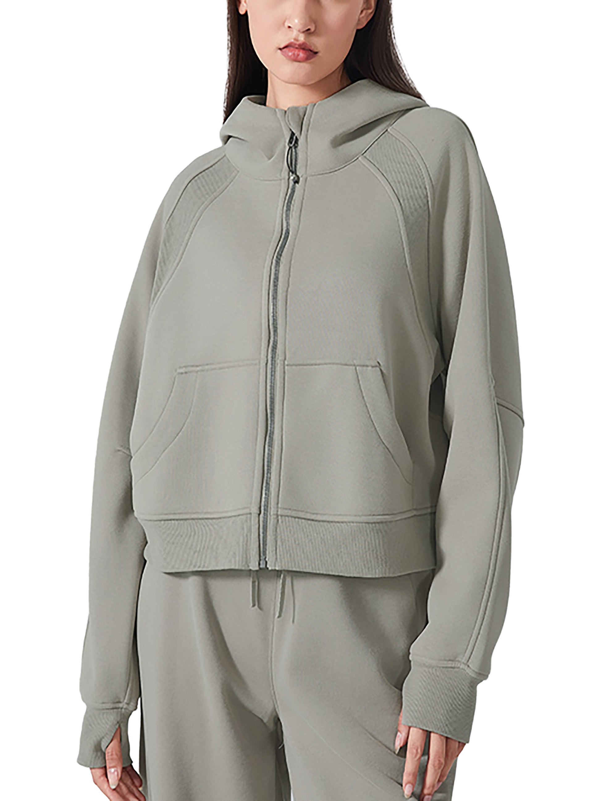 Person wearing a gray zip-up hoodie on a white background