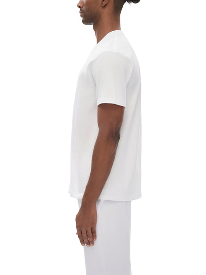 Person wearing a plain white t-shirt and pants on a white background