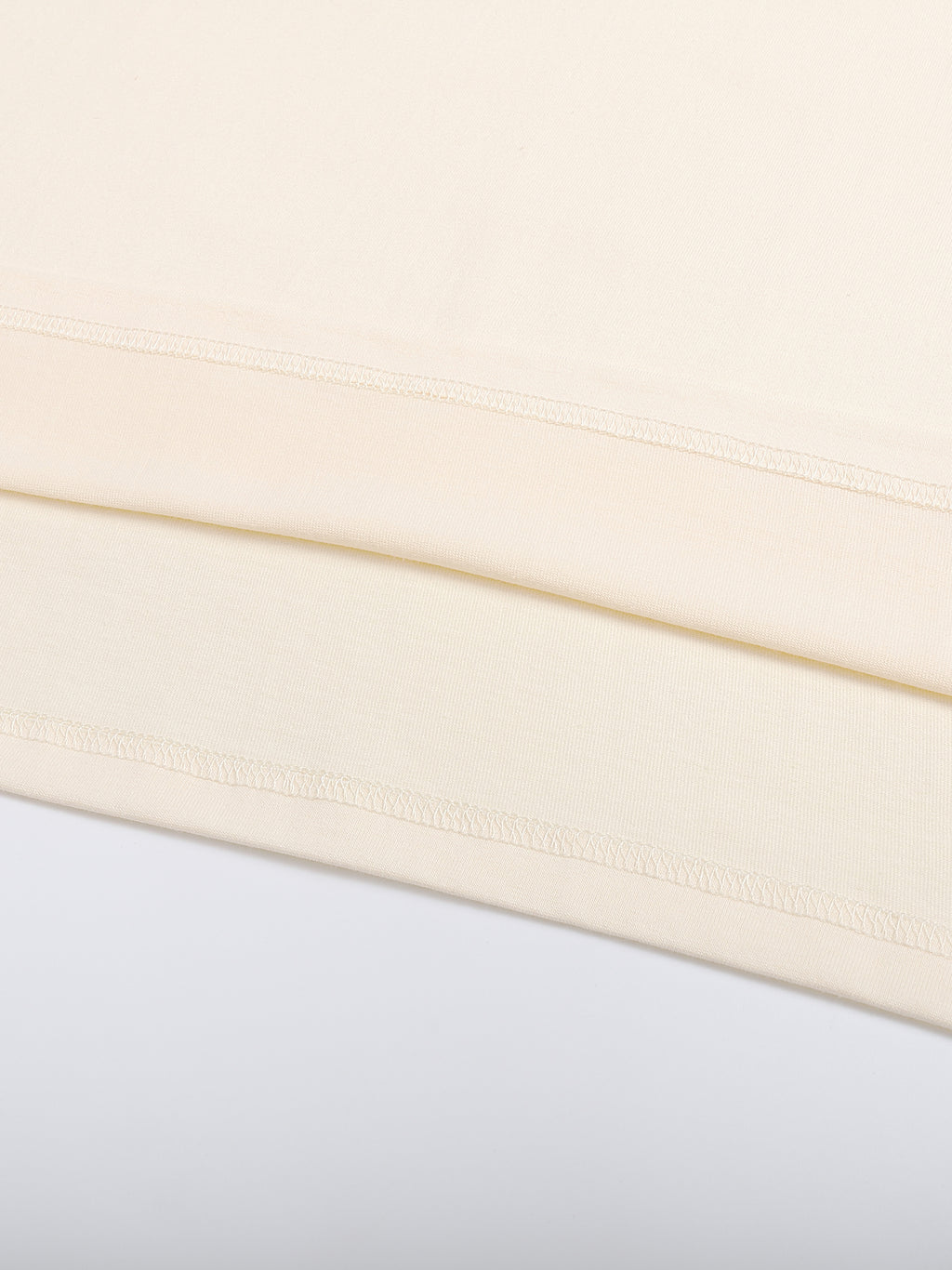 Close-up of a beige fabric with a subtle pattern on a light gray background