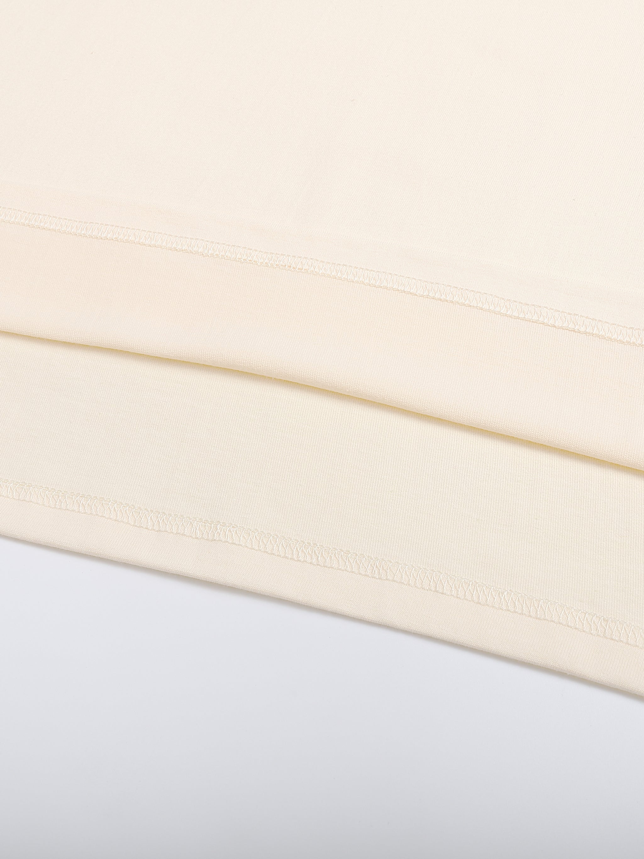 Close-up of a beige fabric with a subtle pattern on a light gray background