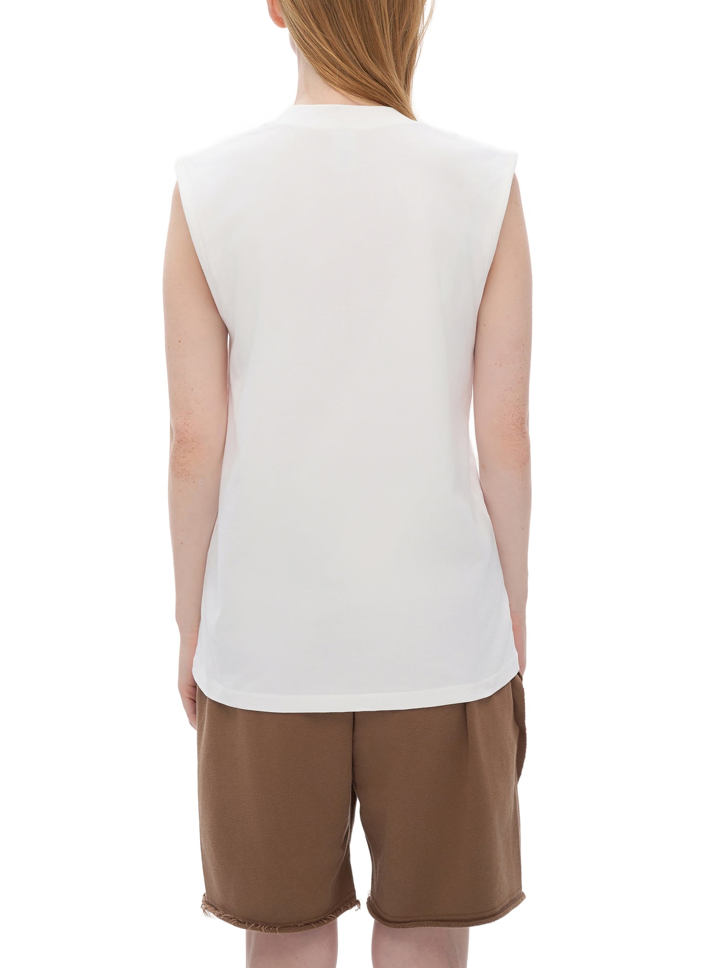 Person wearing a white sleeveless tank top and brown shorts on a white background