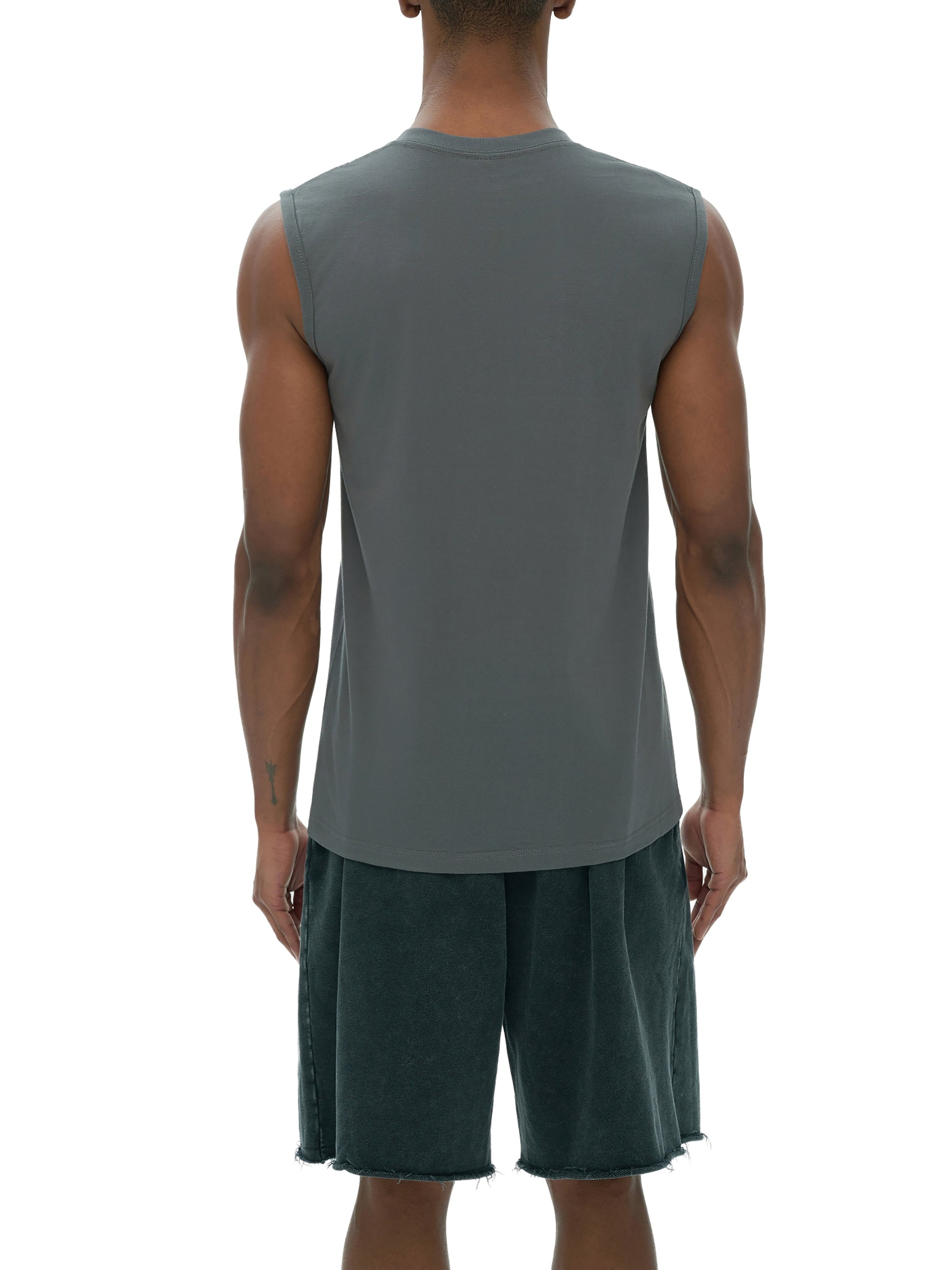 Person wearing a gray sleeveless shirt tank top and green shorts on a white background