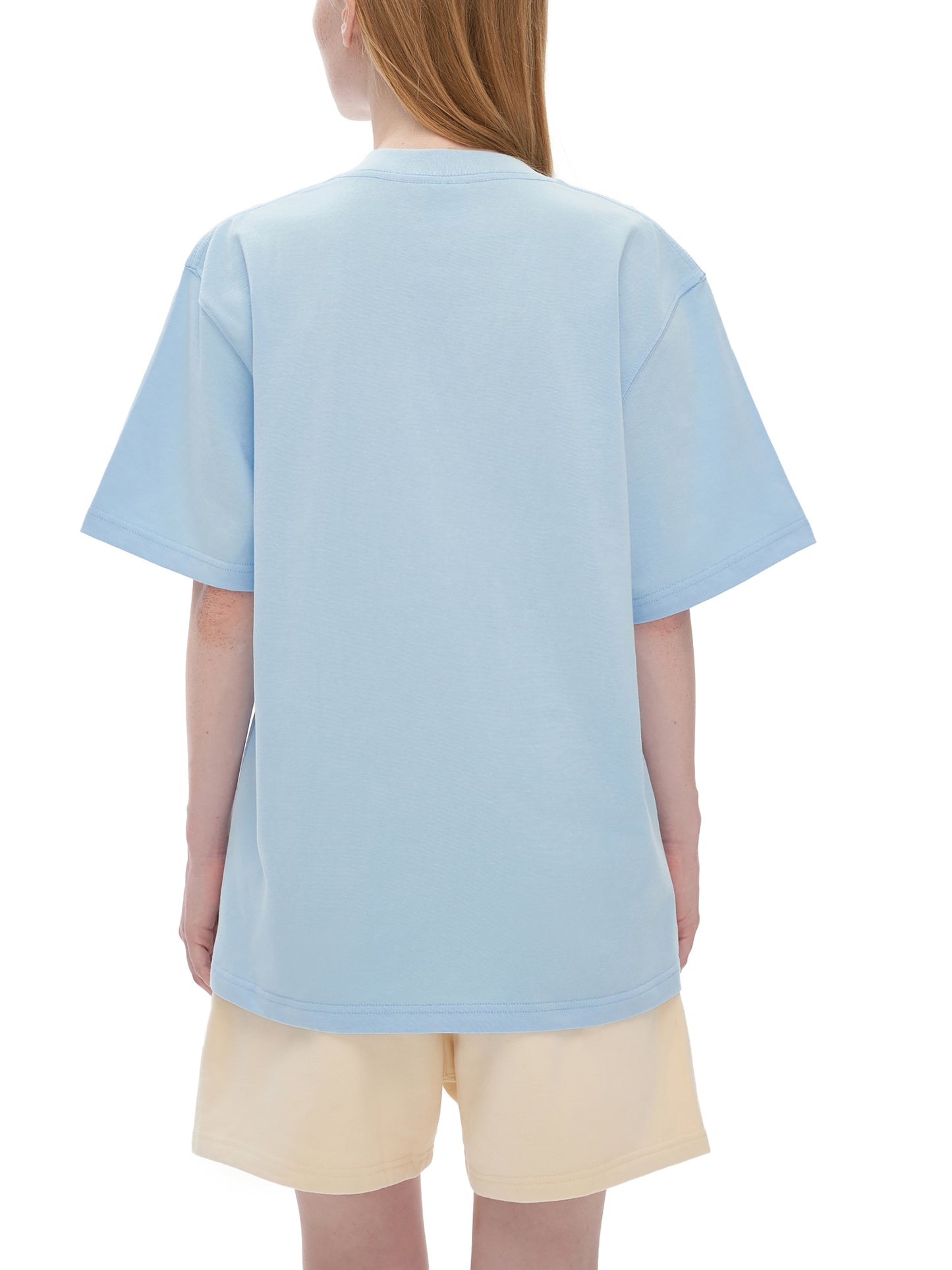 Person wearing a light blue t-shirt and beige shorts on a white background