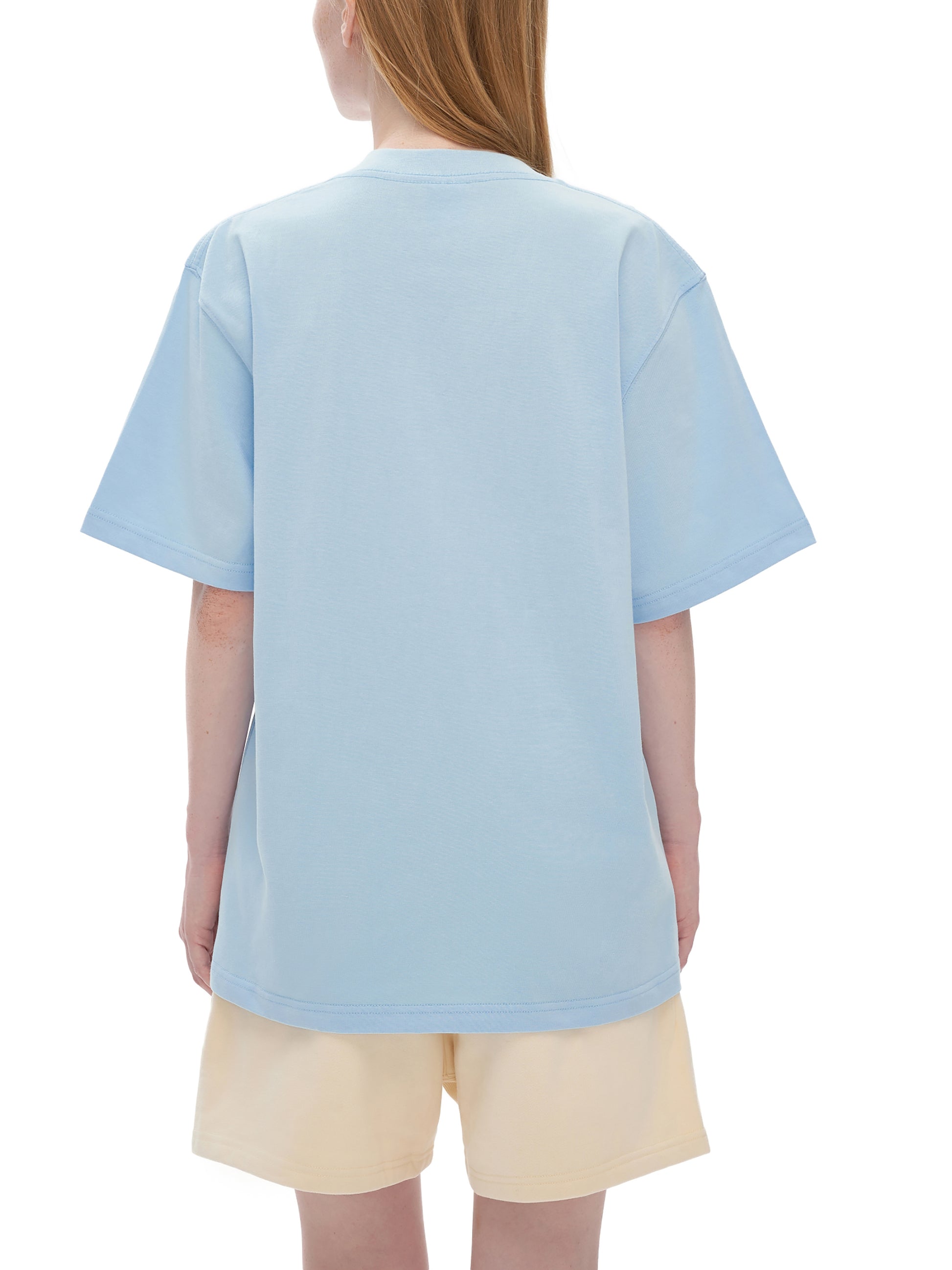 Person wearing a light blue t-shirt and beige shorts on a white background