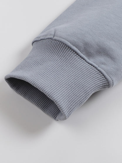 Close-up of a gray sweater sleeve on a light gray background