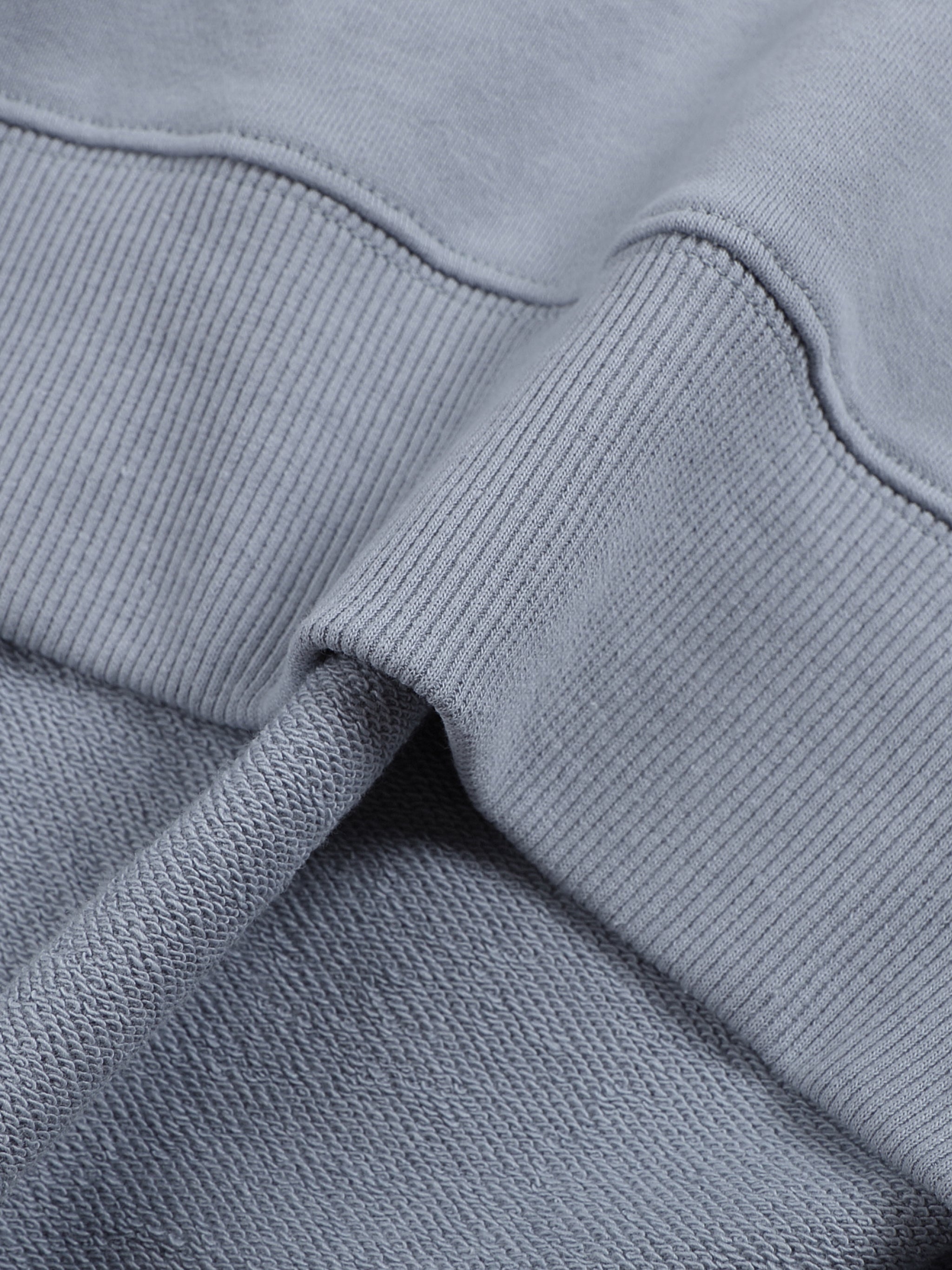 Close-up of a gray sweatshirt with a focus on texture and stitching.