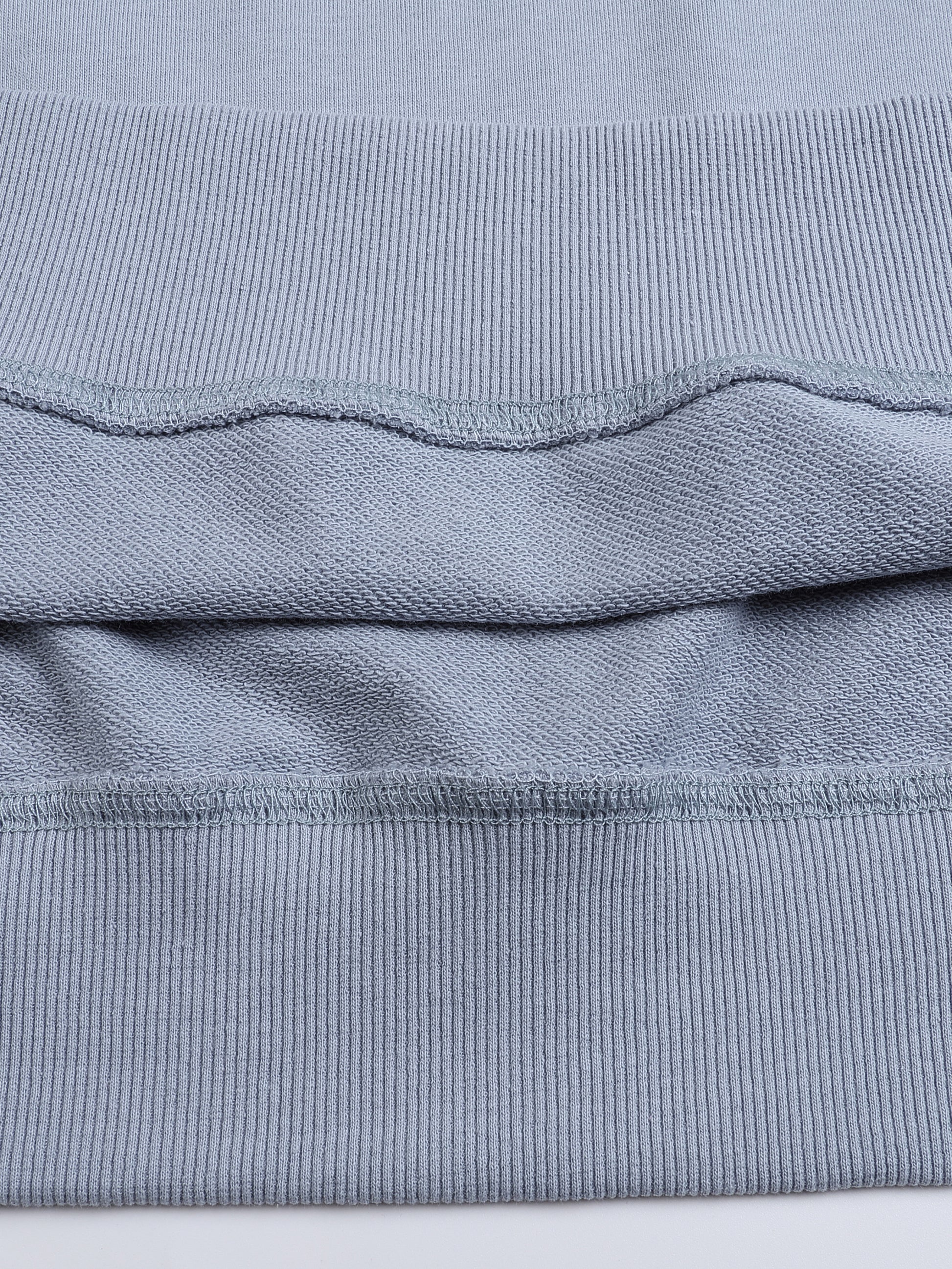 Close-up of a folded blue fabric with visible texture on a white background