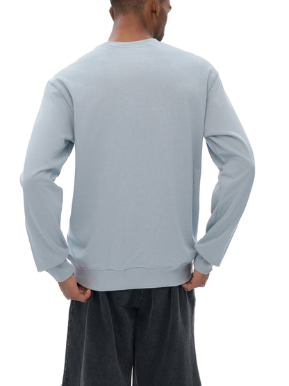 Person wearing a light gray sweatshirt and dark gray pants on a white background
