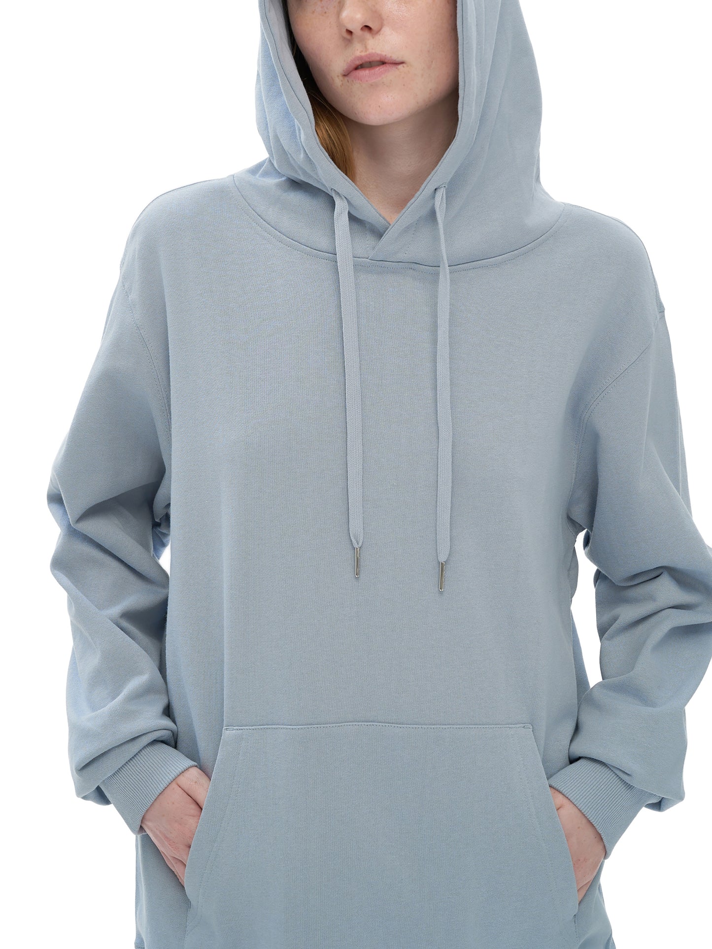 Person wearing a light blue hoodie on a white background